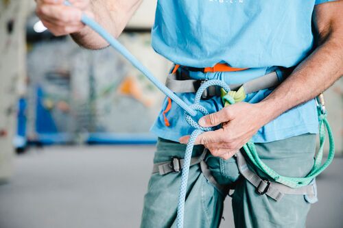 Mann zeigt an einem Seil den Sicherheitsknoten